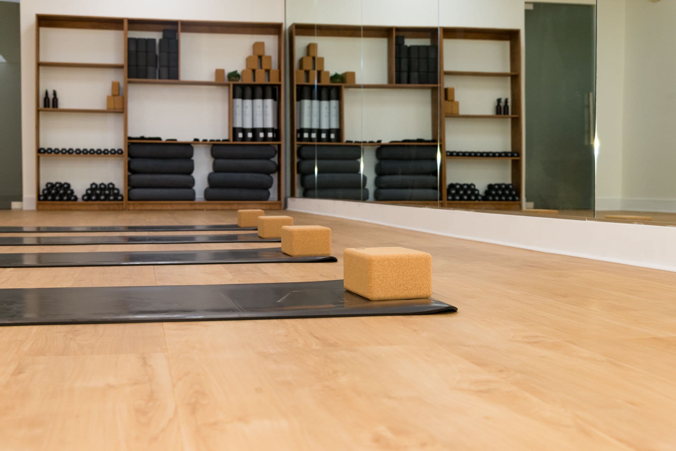 Ekafusion Wellness studio with yoga mats, cork blocks, mirrored walls, and props.